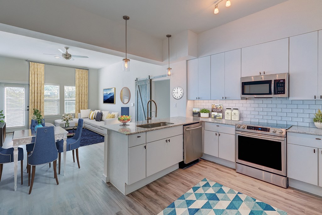 an open kitchen and living room with a dining area and a table and chairs