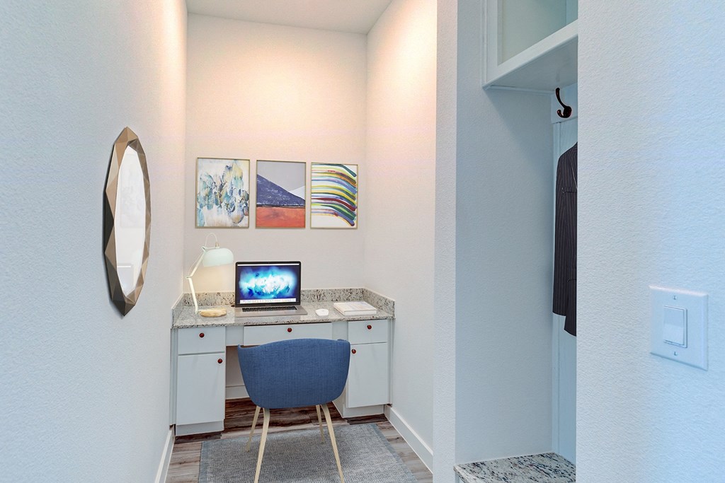 a desk with a computer and a chair in a room with a closet