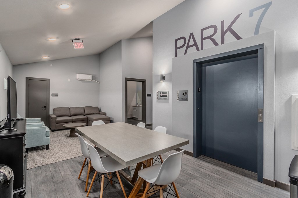 a dining room with a table and chairs in front of a parking door