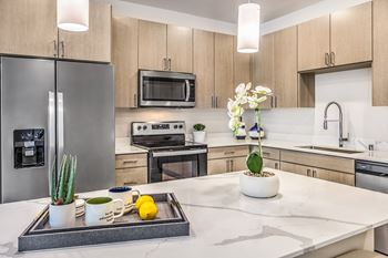 a kitchen with a large island and stainless steel appliances