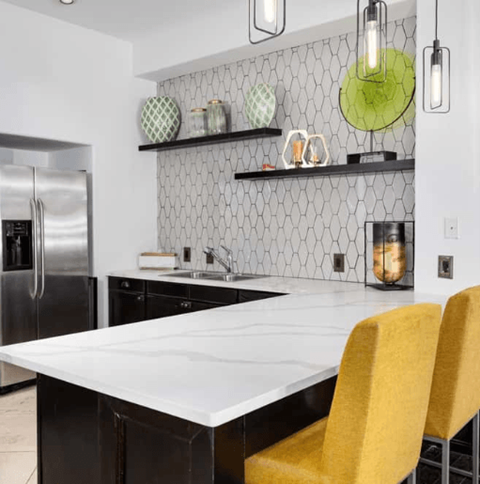 A kitchen with a white counter top and yellow chairs.