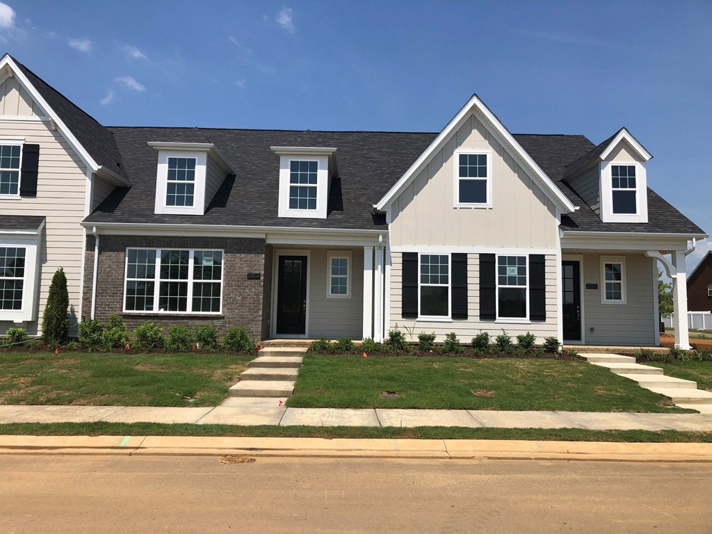 a white house with black shutters and a lawn