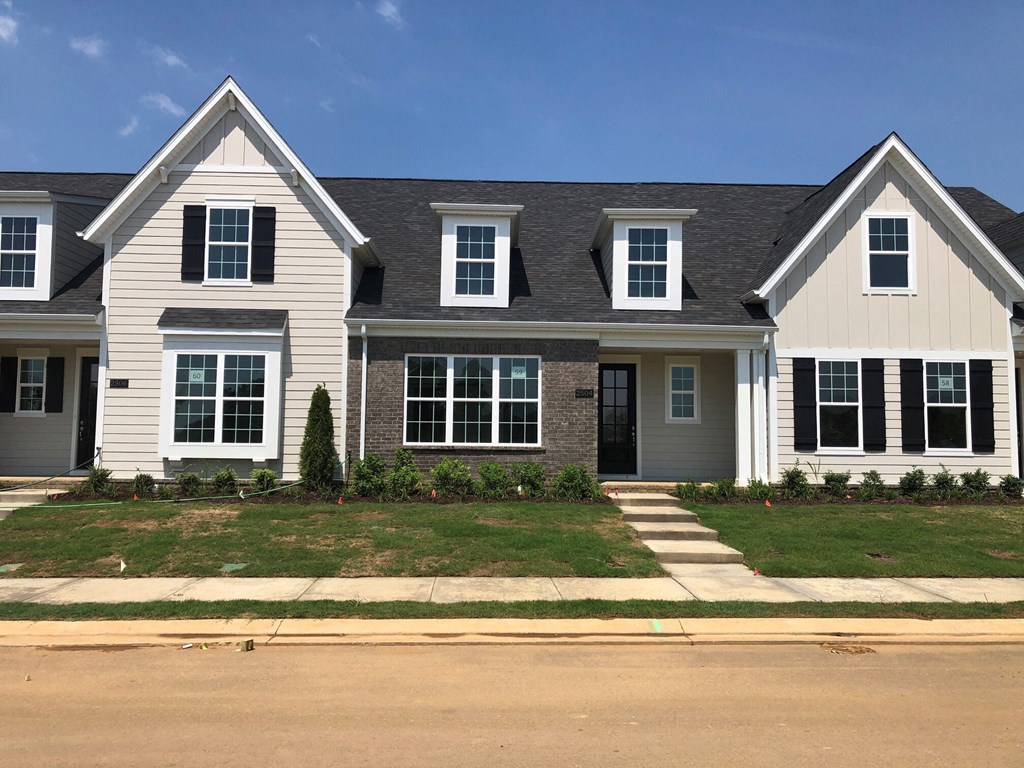 a white house with white siding and a black roof