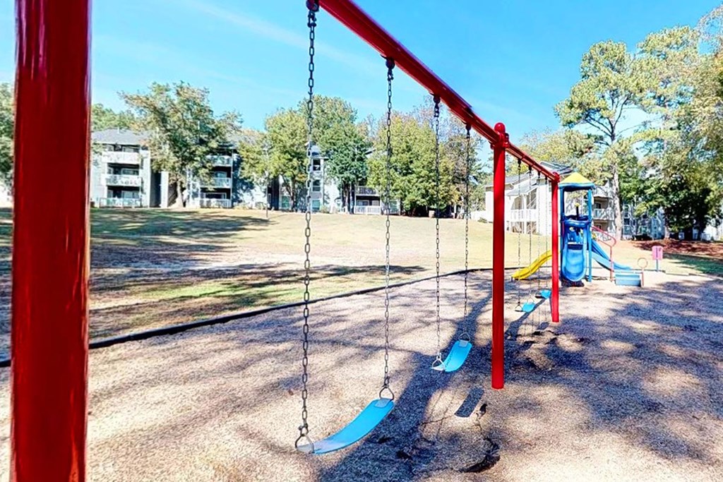 1 Park Central Apartments in Peachtree Corners photo of a swing set in a park with buildings in the background