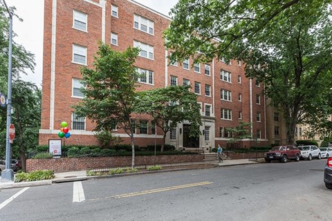 A red brick building with a tree in front of it.
