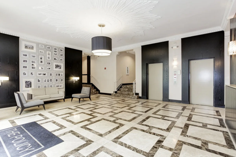 A spacious lobby with a marble floor and a wall of windows.