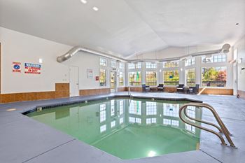 A large indoor swimming pool with a diving board. at Cedar Crest, Beaverton
