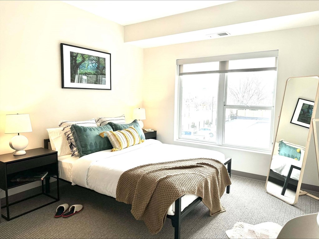 a bedroom with a bed and a large window