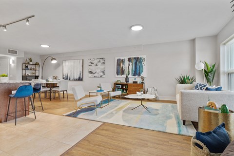 A living room with a blue chair and a white couch.