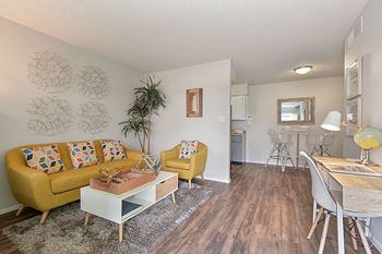 a living room with a yellow couch and a white coffee table