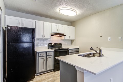 an empty kitchen with a sink and a refrigerator