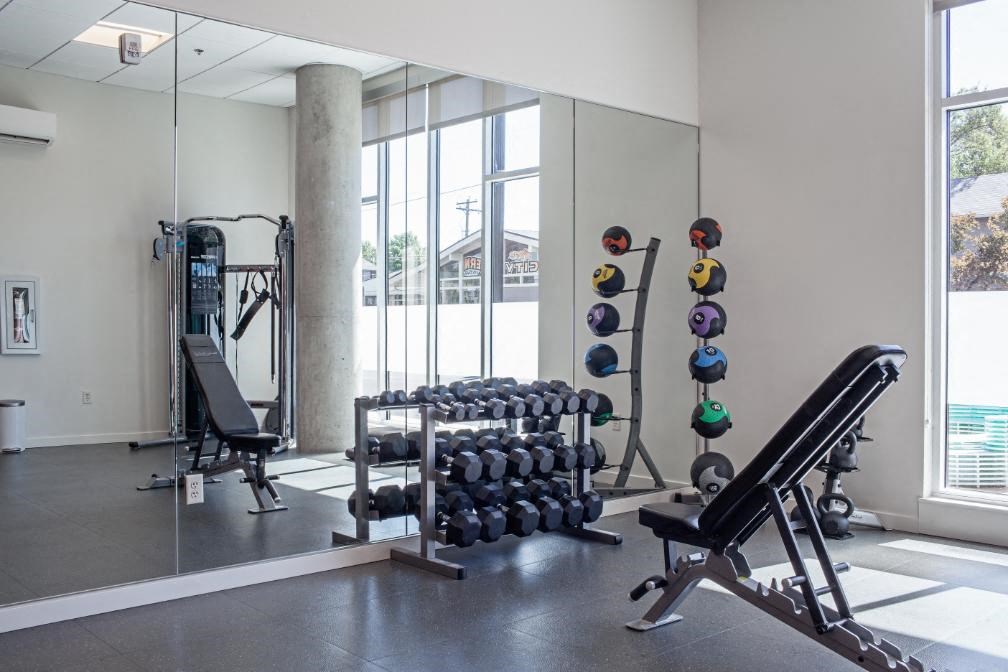 a home gym with weights and mirrors