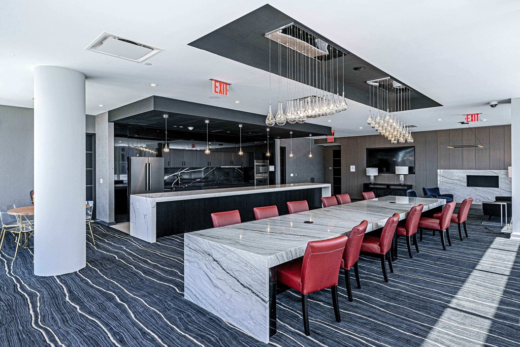 3thirty3 new rochelle ny apartment high rise photo of co-working area with large community table work station made of marble with modern furniture and finishes next to community kitchen area