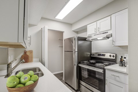 a kitchen with stainless steel appliances and white cabinets