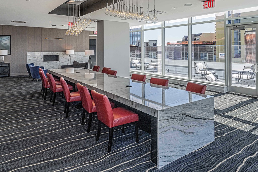 Co-working area at 3thirty3 New Rochelle NY high-rise, featuring a marble community table, modern furniture, and window wall with city skyline view.
