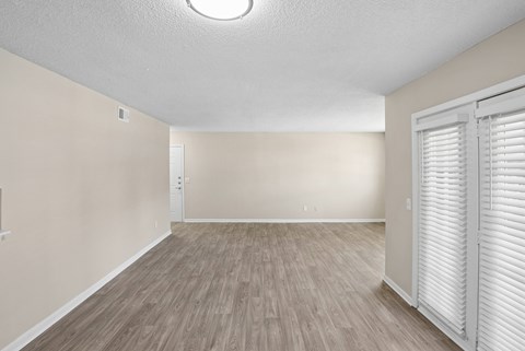 A room with light brown flooring and white walls.