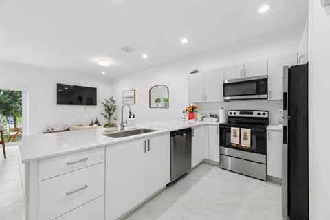 A modern kitchen with white cabinets and stainless steel appliances.