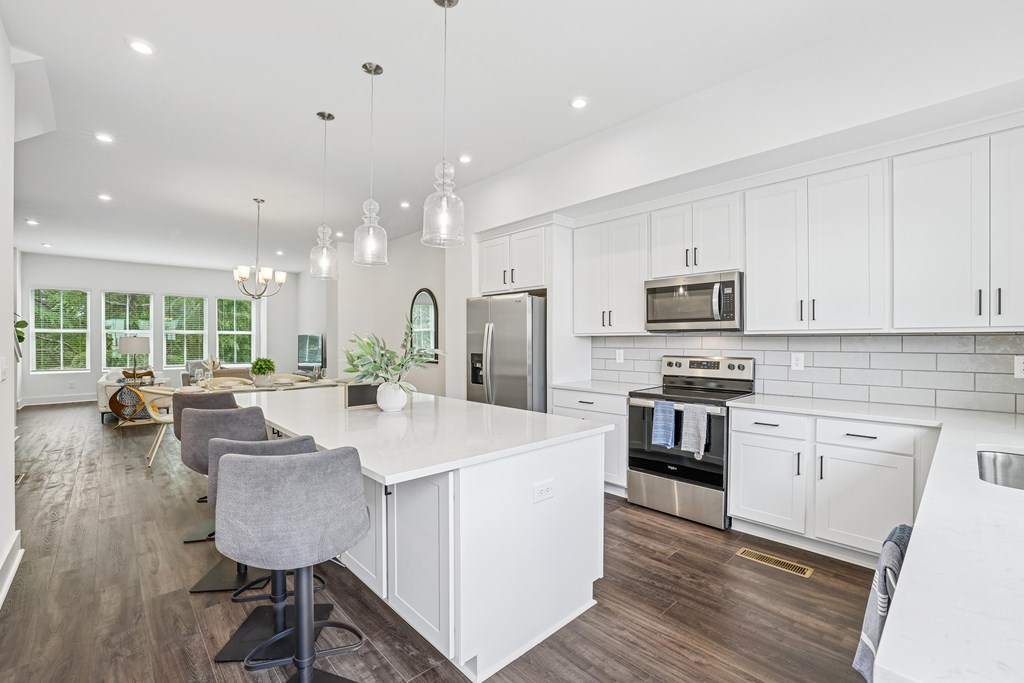 Modern kitchen with white cabinets and a central island at Henley Avondale in Avondale Estates, GA.