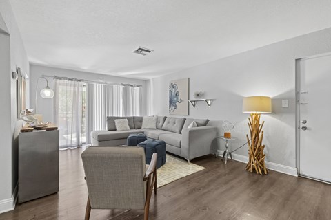 A living room with a grey couch and a chair.