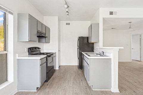 A kitchen with white cabinets and a white island.