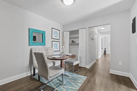 A dining room with a table and chairs.