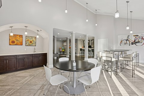 A modern dining room with a round table and white chairs.