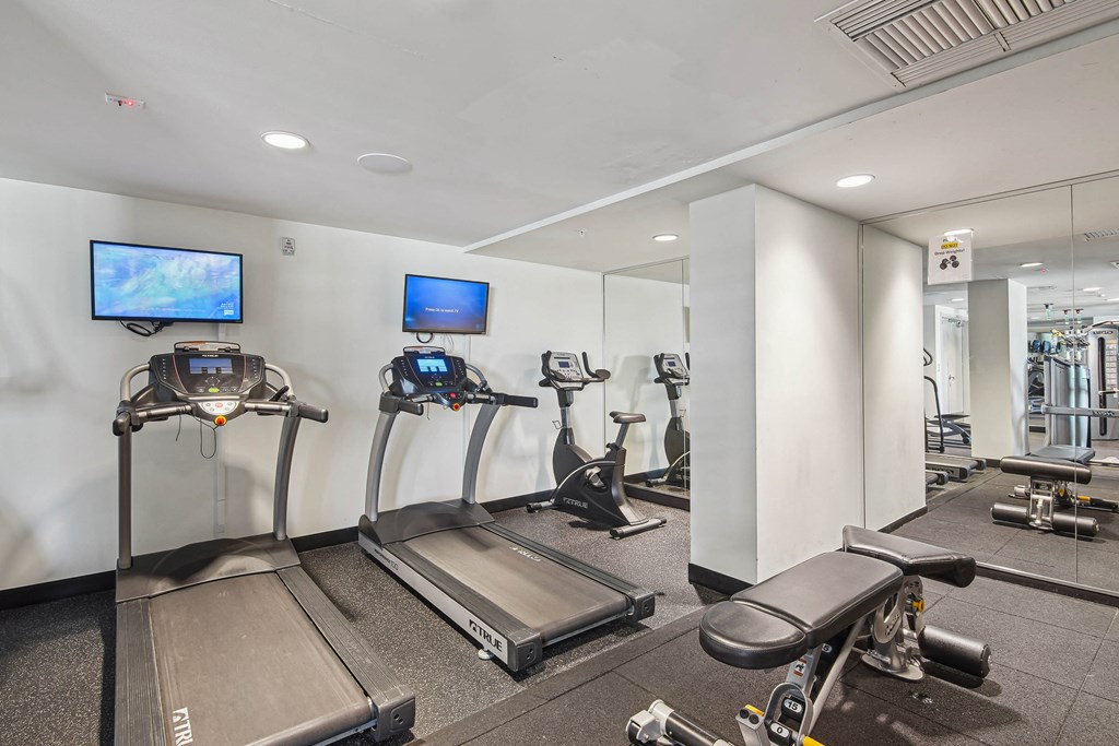 Apartments for Rent in Riverview Miami, FL– Riverview One Apartments -   A gym with treadmills, exercise bikes, and a television.