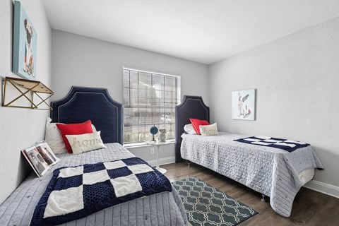 A bedroom with two beds and a window.