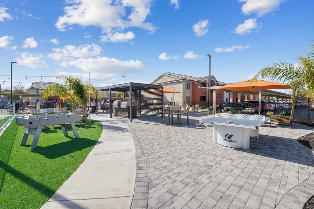 A white table tennis table is in the middle of a paved area.