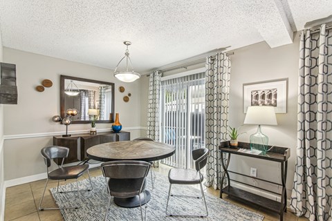 A living room with a round table and chairs.