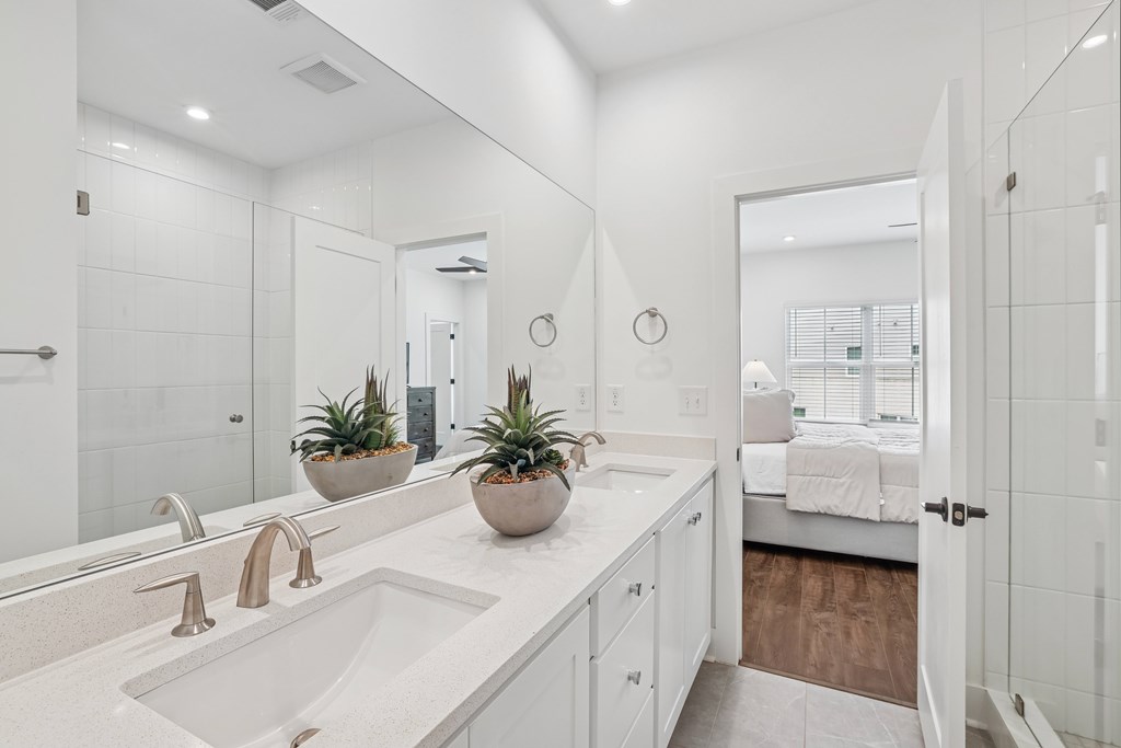 White bathroom with sink and large mirror at Henley Avondale in Avondale Estates, GA, in a pet-friendly community.”