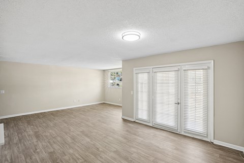 A room with wooden flooring and white walls.