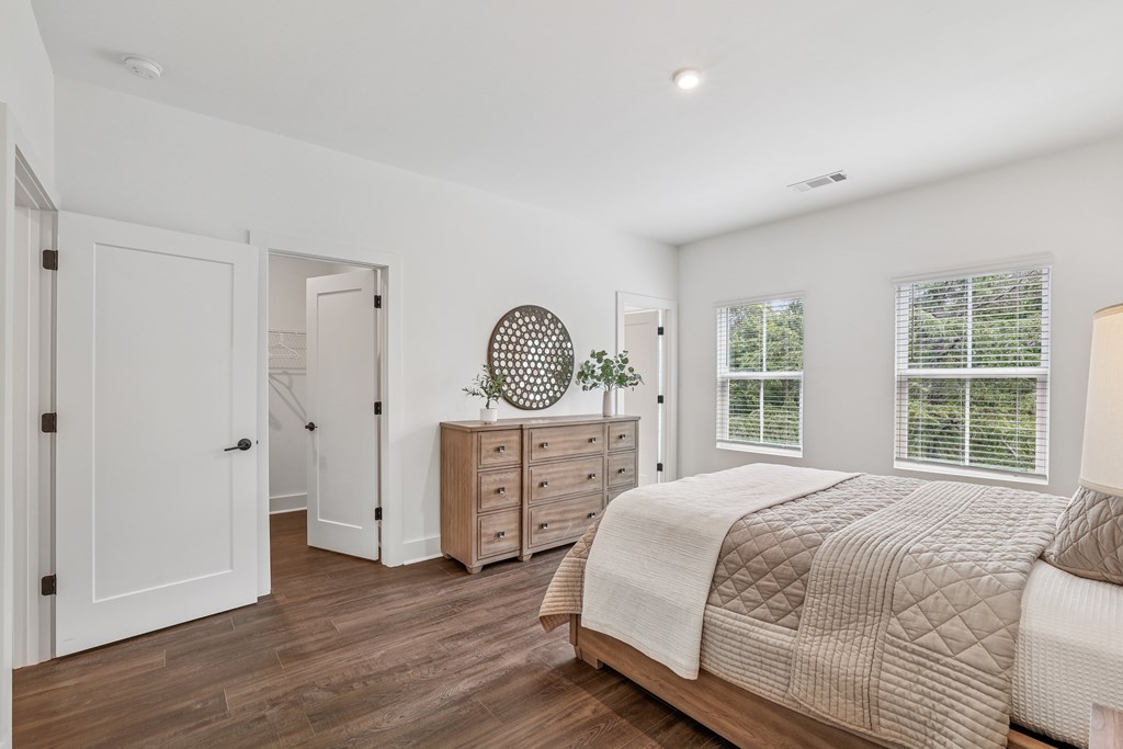 Bedroom with two windows bringing in natural light at Henley Avondale in Avondale Estates, GA, a pet-friendly community.