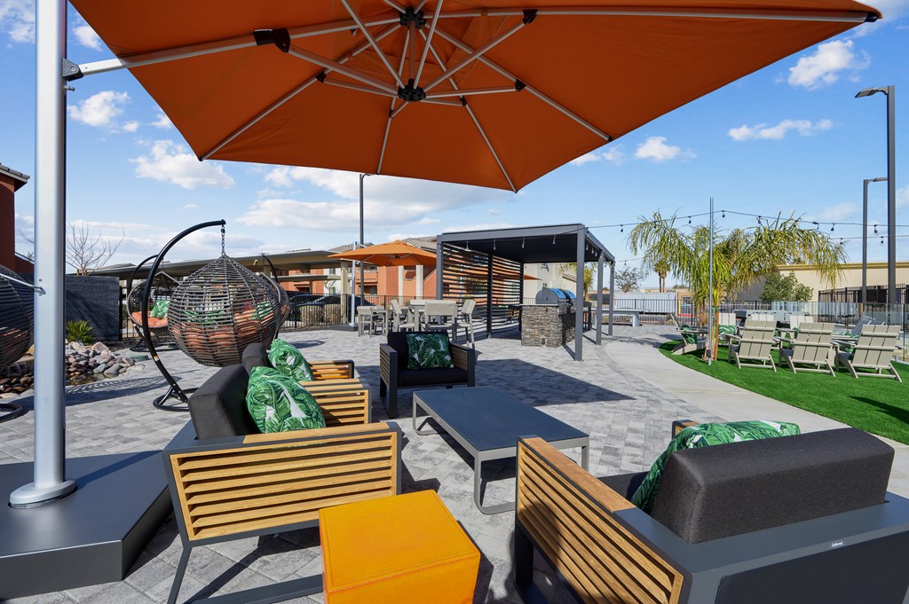 A patio with orange umbrellas and wooden chairs.
