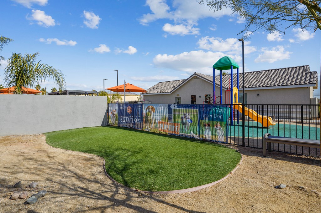 A playground with a green slide and a mural on the wall.