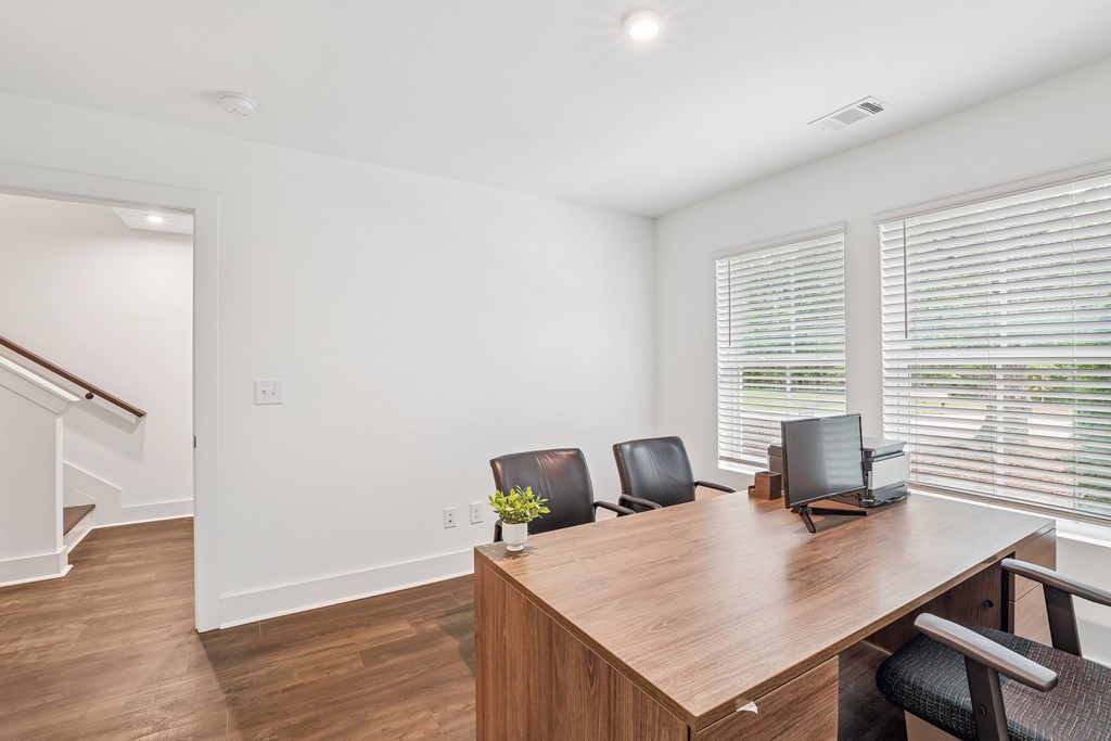 A conference room with a long table, chairs, and a laptop.