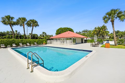 A swimming pool with a red roofed building in the background.