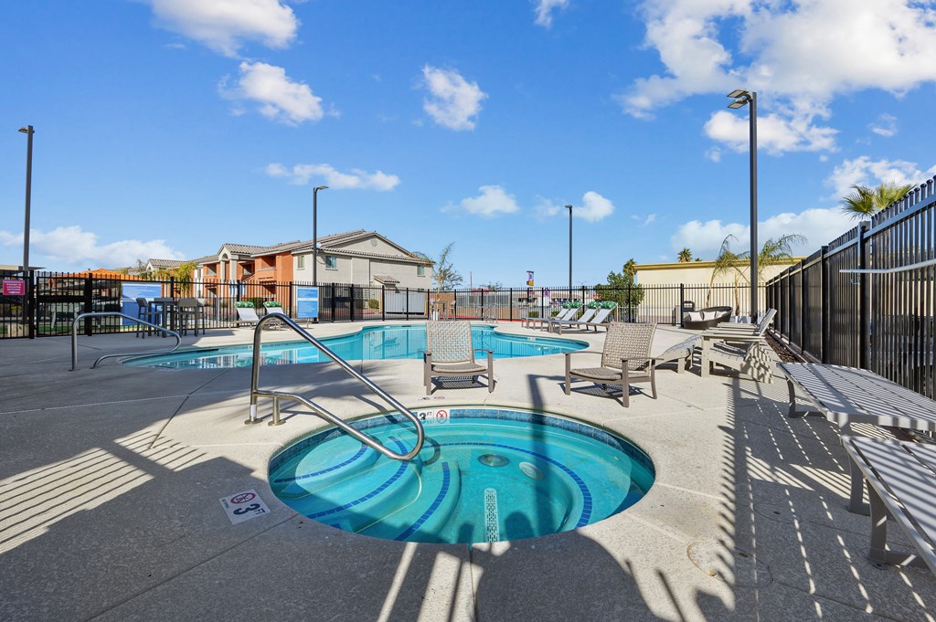 A pool with a slide and sun loungers.