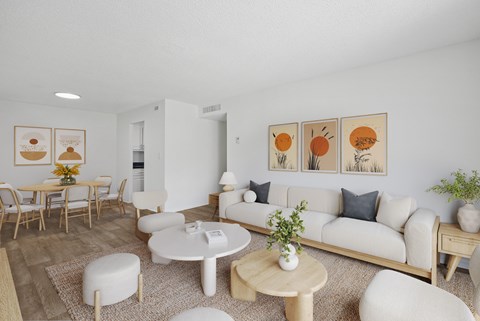 A living room with a white couch, a coffee table, and a dining table with chairs.