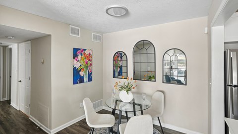 A dining room with a glass table and chairs.