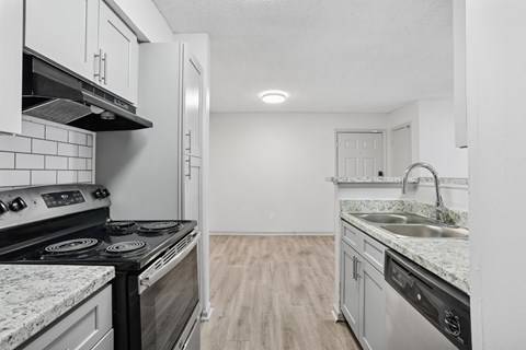 A kitchen with a black stove top oven and a white refrigerator.