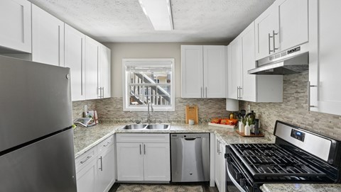 A kitchen with white cabinets and a black stove top oven.
