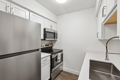 A modern kitchen with stainless steel appliances and white cabinets.