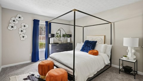 A bedroom with a white bed and a black metal frame.