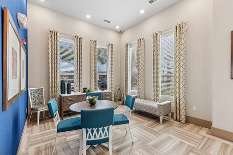 A dining room with a blue table and chairs.