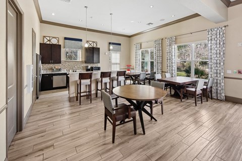 A kitchen with a dining table and chairs.