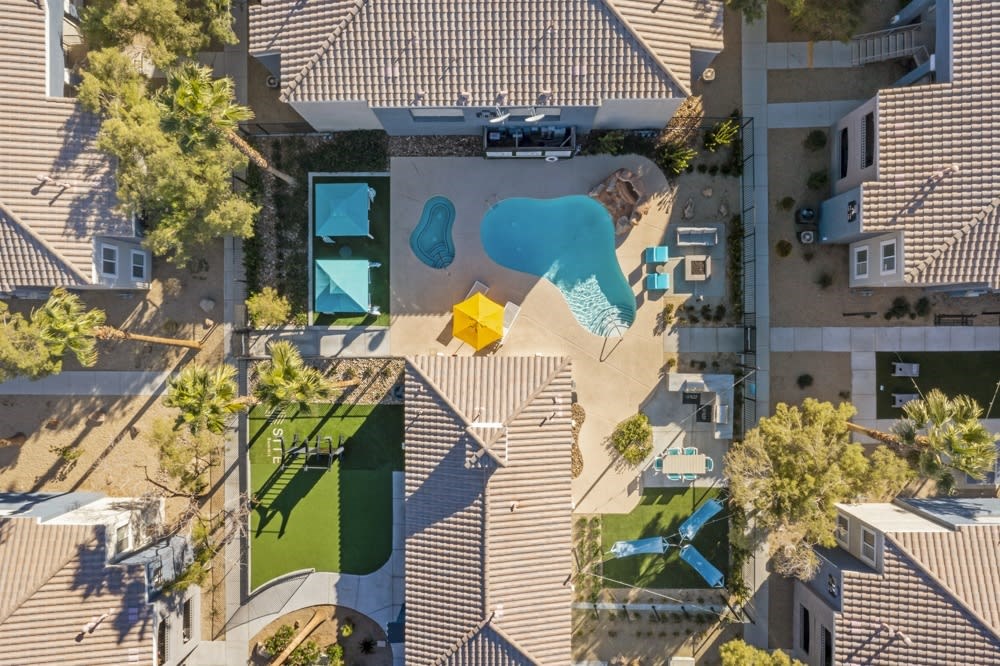an aerial view of a house with a pool in the backyard