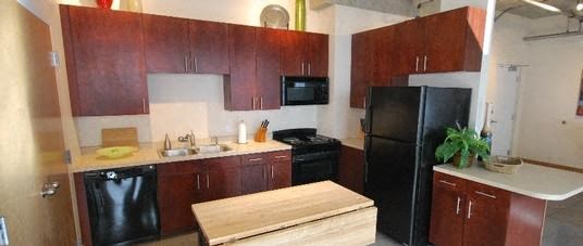 a kitchen with a black refrigerator freezer and a black stove top oven