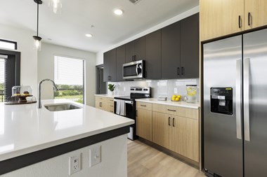 a modern kitchen with white countertops and dark wood cabinets