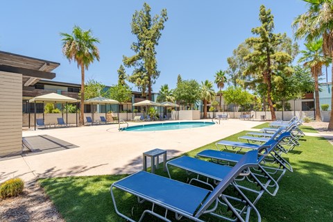 Resort-style pool seating area at Sono Tempe Apartments in Tempe, AZ with shaded loungers and outdoor relaxation space.